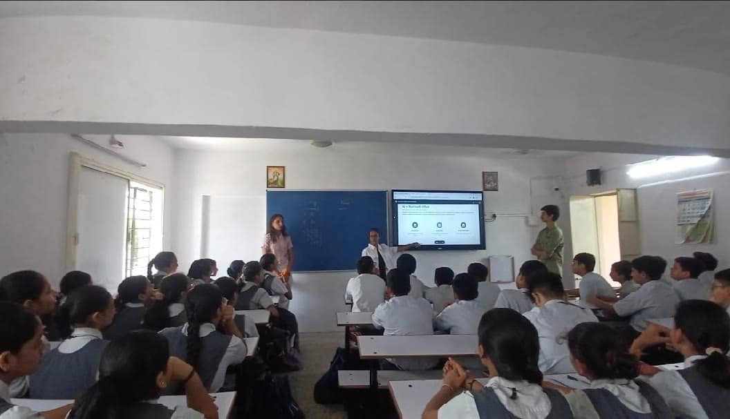 A full classroom facing a screen at the front, shot from the back of the room.