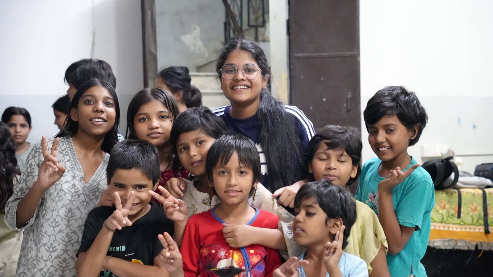 A group of children and volunteers smiling at the camera.